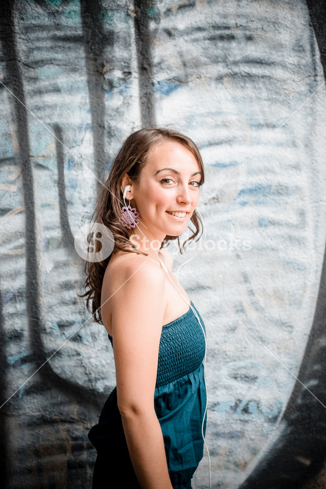 Woman enjoying music with phone player in the city