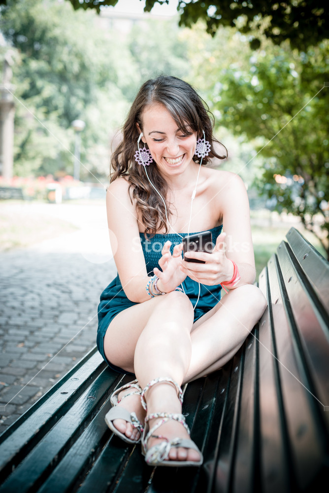 Woman enjoying music with phone player in the city