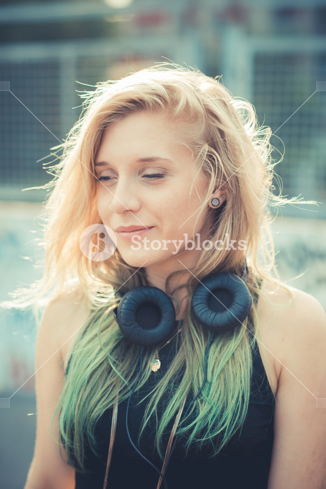 Stylish young woman enjoying music in the city