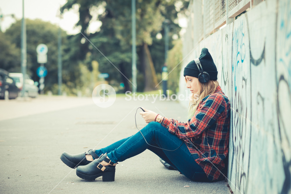Stylish young woman enjoying music in the city