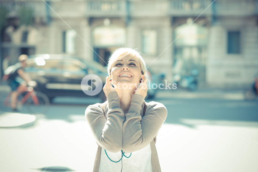 Stylish young woman enjoying music in the city