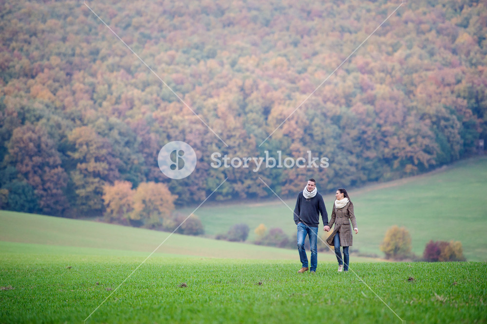 Lovely couple strolling, hand in hand. Vibrant autumn scenery. Royalty ...