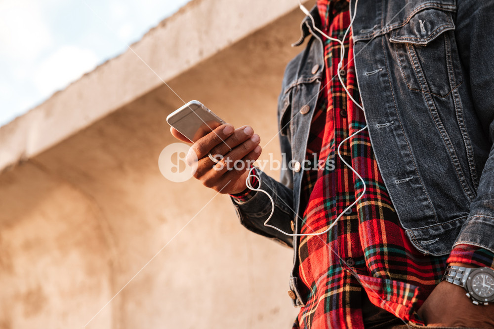 Photo of a young man enjoying the beach and listening to music