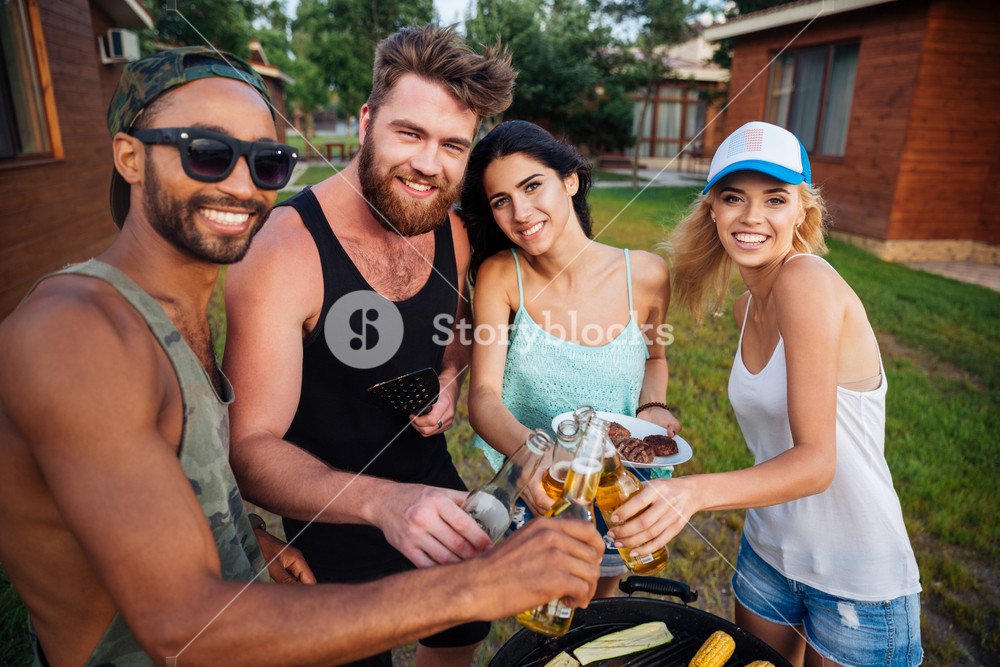 Group of happy smiling friends drinking beer and having barbecue ...