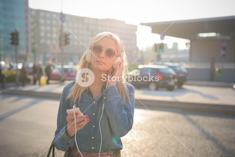 Young woman enjoying music in the city with headphones - relaxation and freedom concept