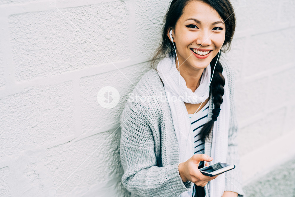 Young woman enjoying music with earphones, smiling - technology, happiness, music concept