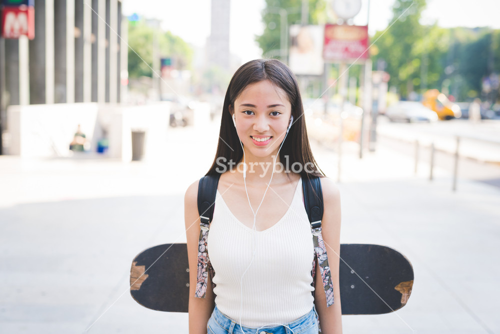 Young Asian woman skater enjoying music, smiling - sportive, music, happiness, relaxing concept