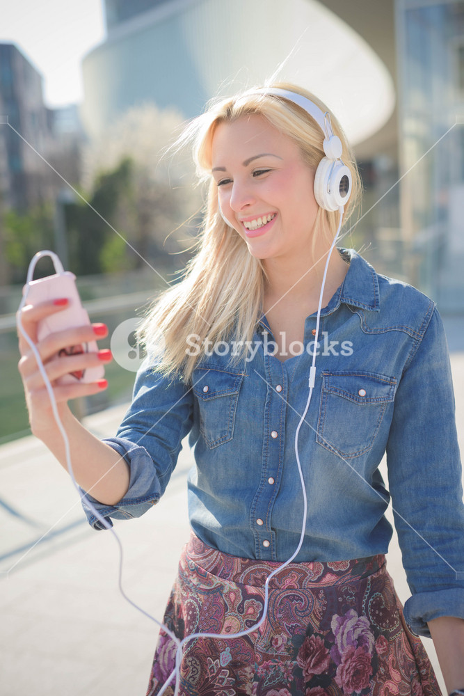 Young woman enjoying music in the city with headphones - relaxation and freedom concept