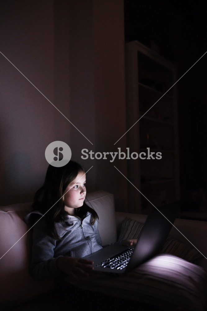 Child at home, exploring technology on the sofa Royalty-Free Stock ...