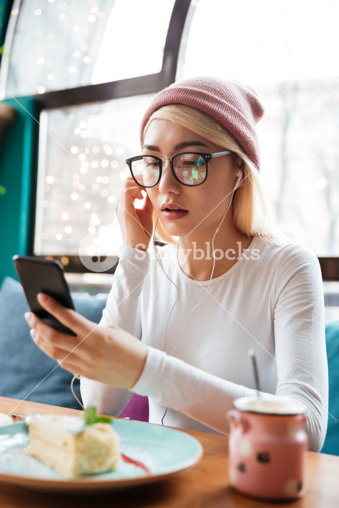 Stylish woman enjoying music and food in a cafe