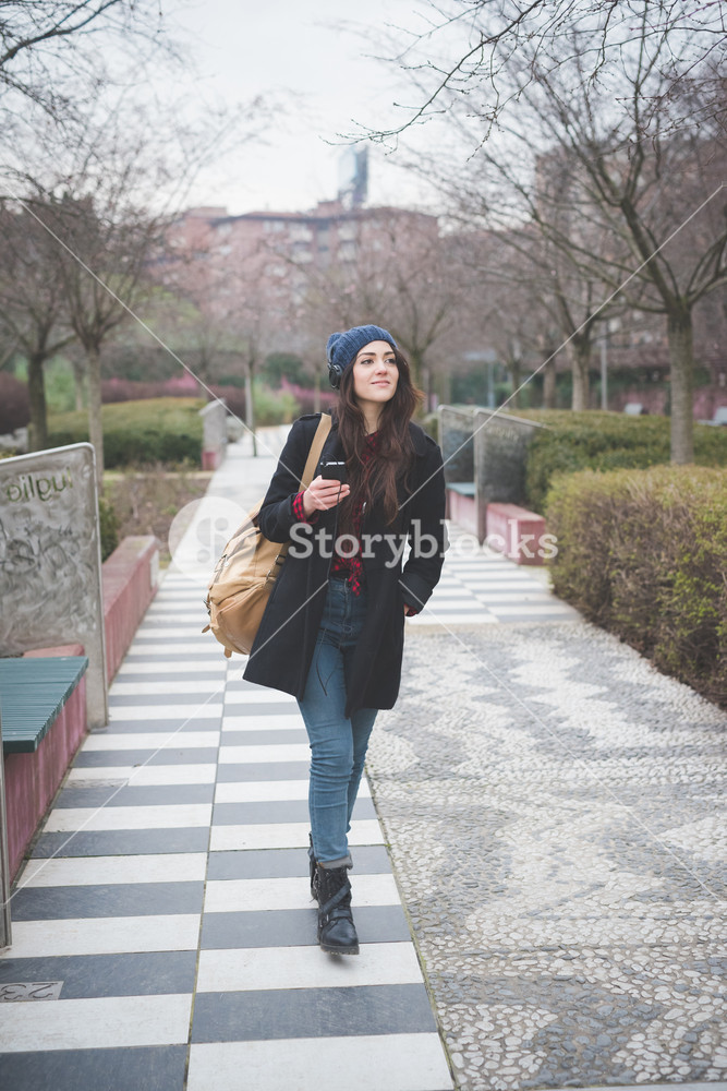 Young woman enjoying music while strolling through the city - carefree, relaxing concept