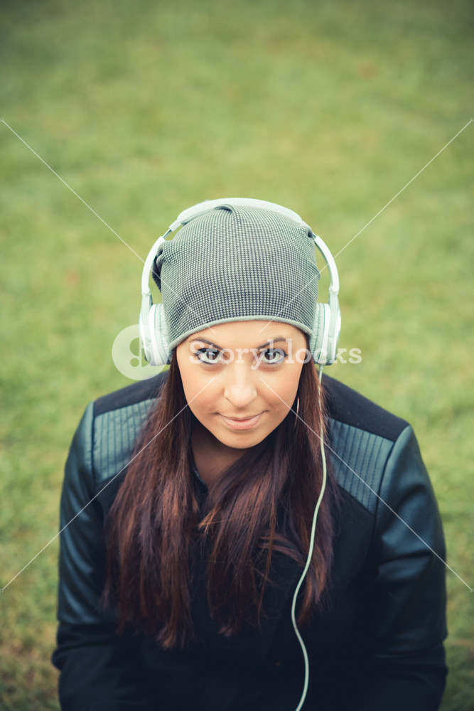 Beautiful woman enjoying music in the autumn park