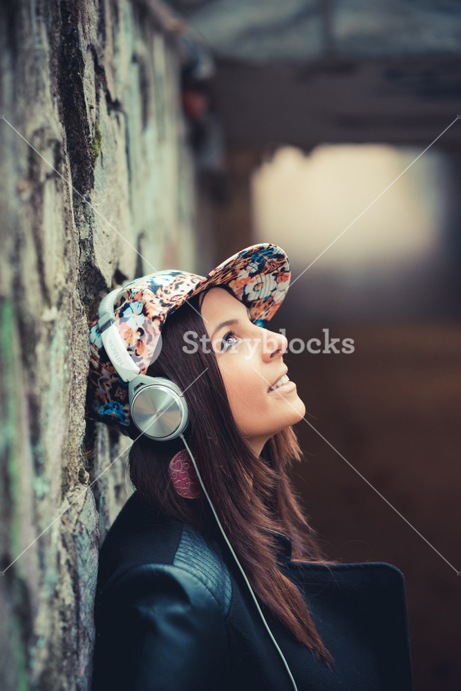 Beautiful woman enjoying music in the park during autumn season