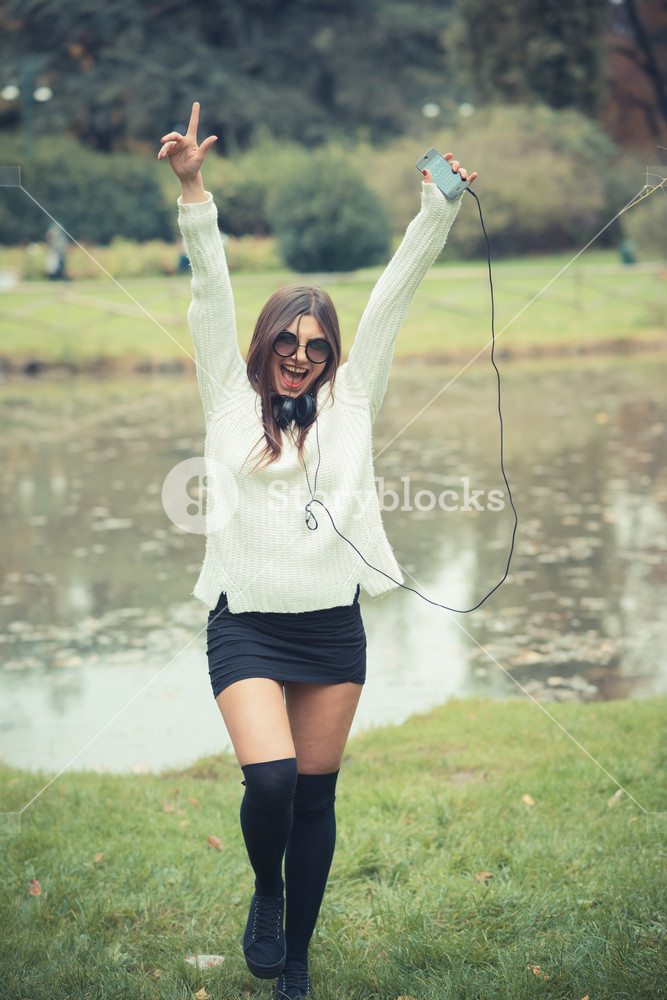 Young woman enjoying music outdoors with headphones