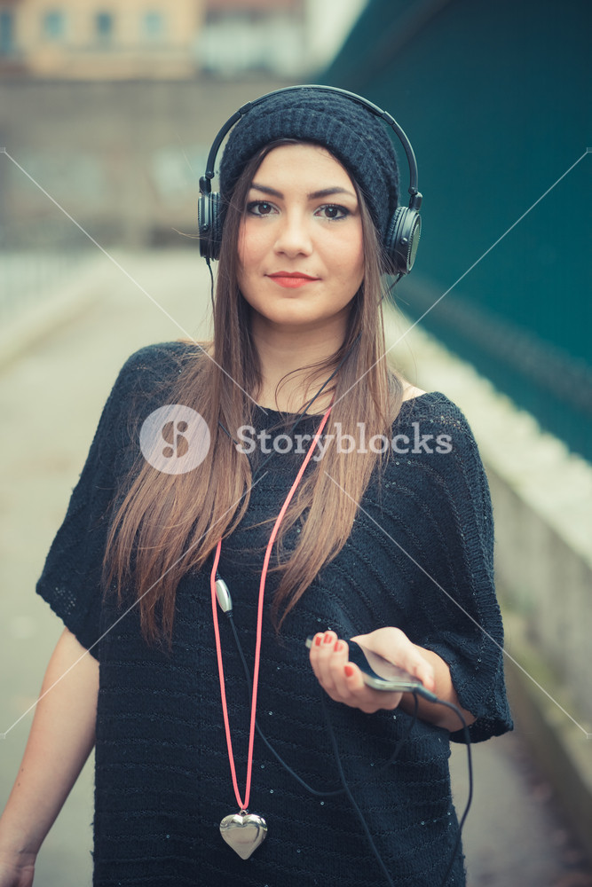 Young woman enjoying music outdoors with headphones