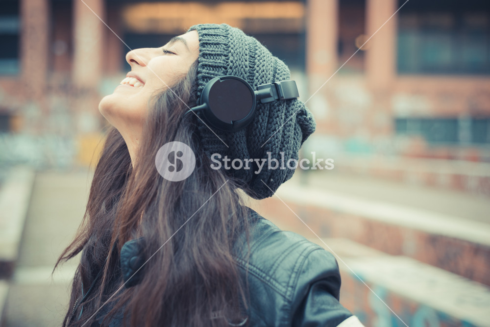 Young woman enjoying music with headphones in the city
