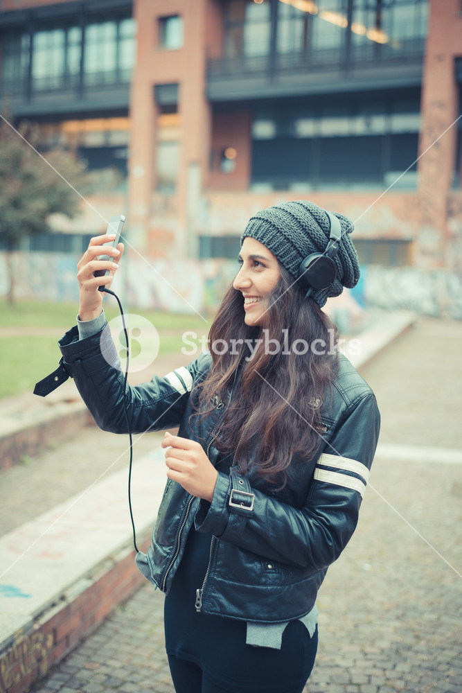 Young woman enjoying music with headphones in the city