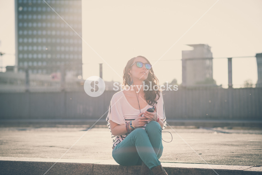 Young woman enjoying music with smartphone in the city