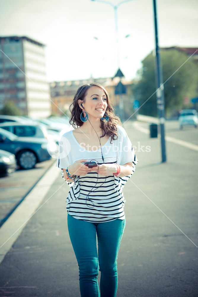 Young woman enjoying music with smartphone in the city