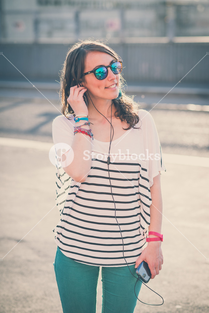 Young woman enjoying music with smartphone in the city