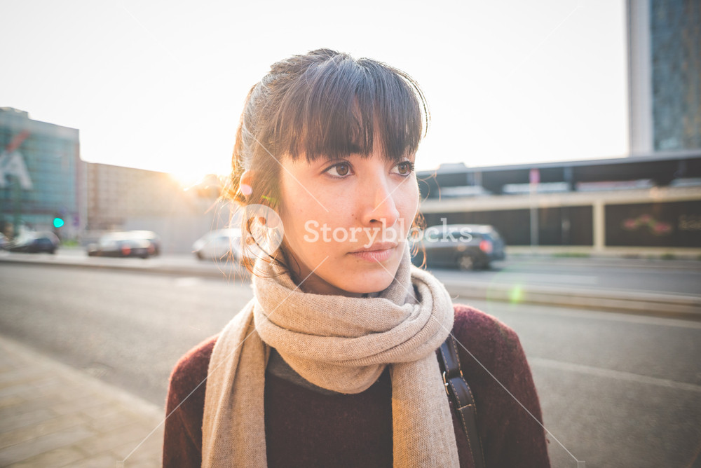 Stylish woman enjoying music with headphones in the city