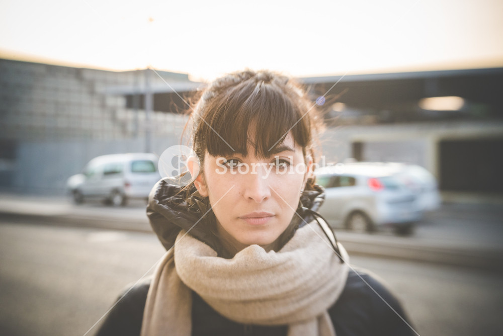 Stylish woman enjoying music with headphones in the city