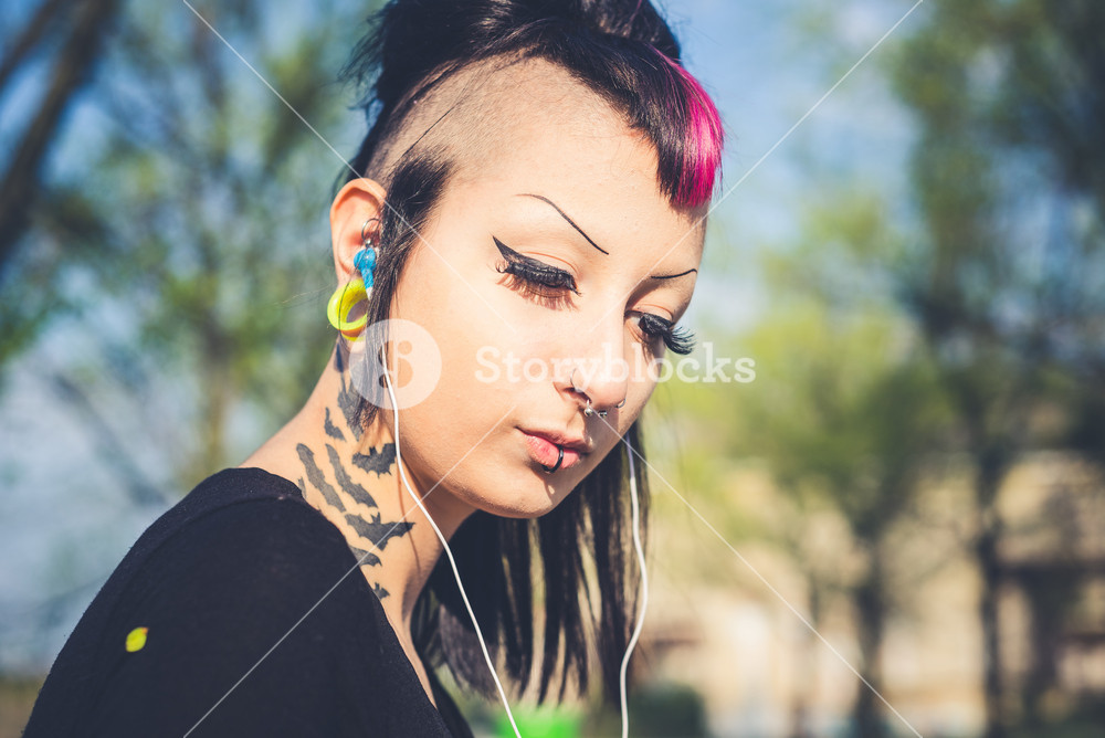 Young woman enjoying music in urban setting
