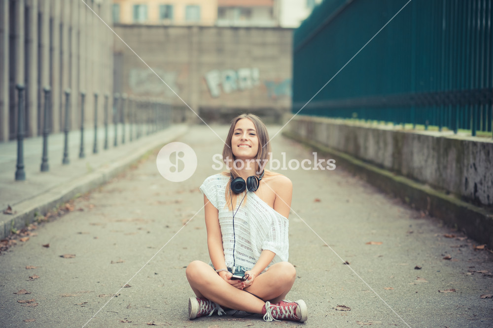 Young woman enjoying music outdoors in autumn