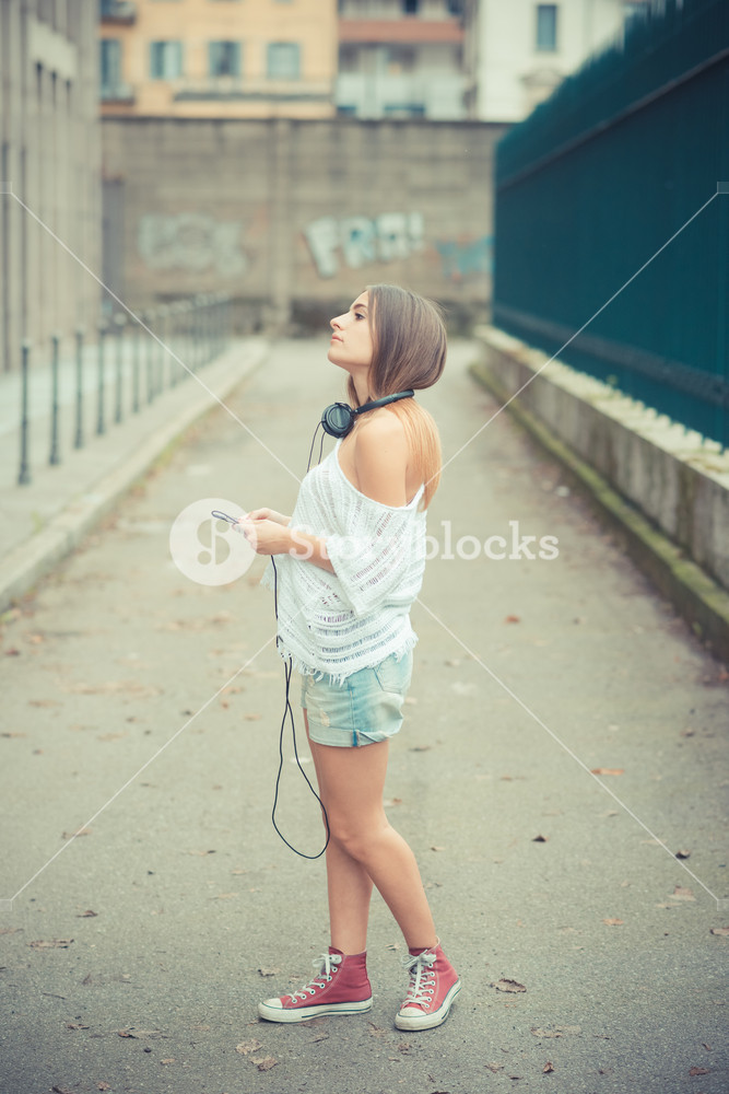 Young woman enjoying music outdoors in autumn