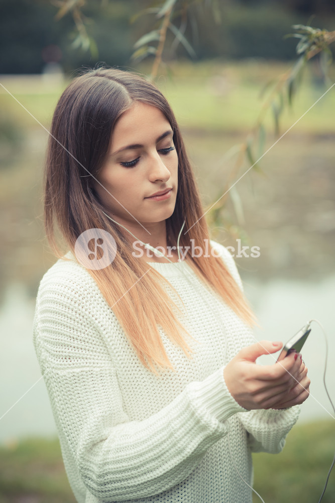 Young woman enjoying music outdoors in autumn
