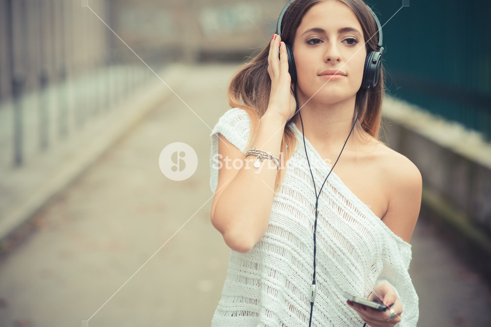 Young woman enjoying music outdoors in autumn