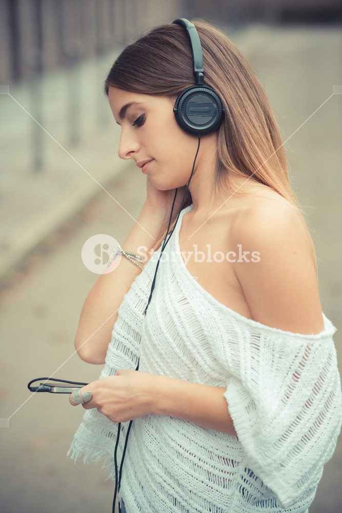 Young woman enjoying music outdoors in autumn