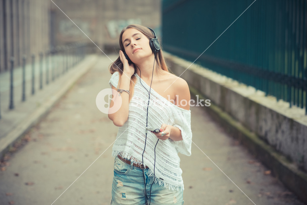 Young woman enjoying music outdoors in autumn