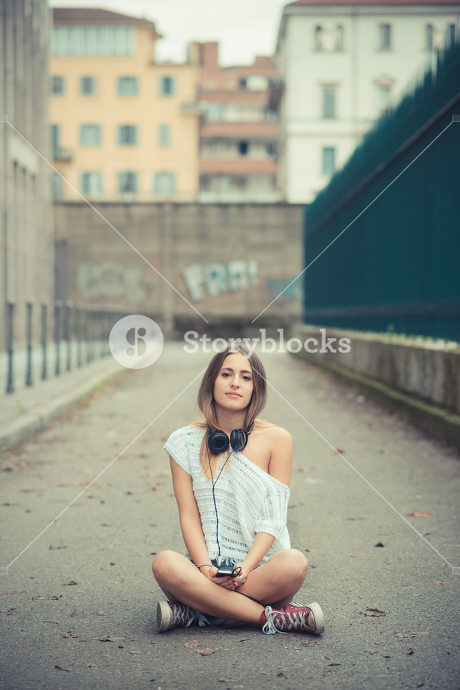Young woman enjoying music outdoors in autumn