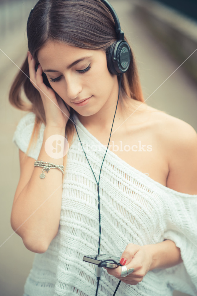 Young woman enjoying music outdoors in autumn