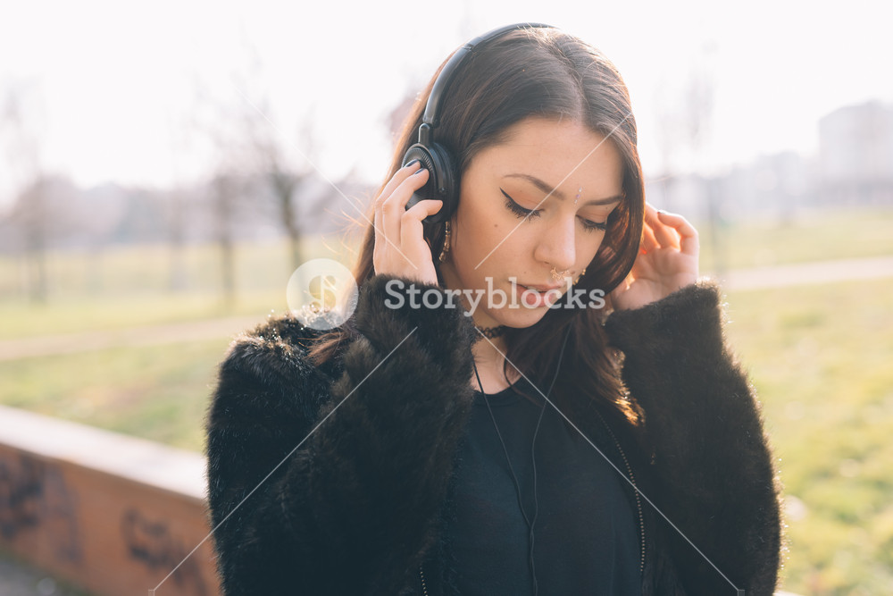 Young woman enjoying music with headphones in the city