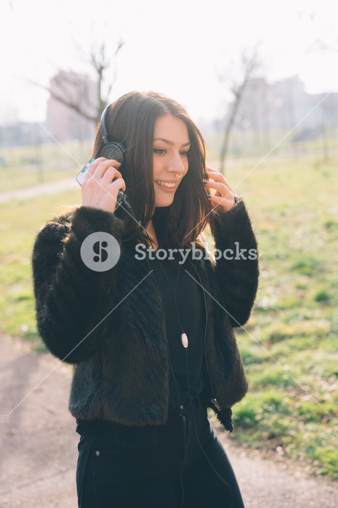 Young woman enjoying music with headphones in the city