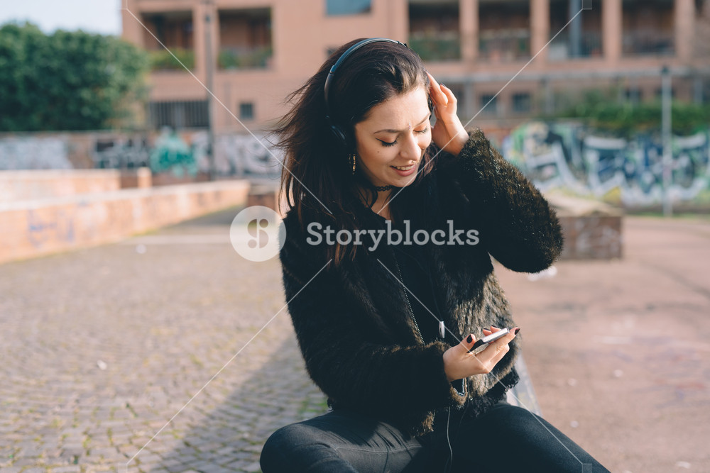 Young woman enjoying music with headphones in the city