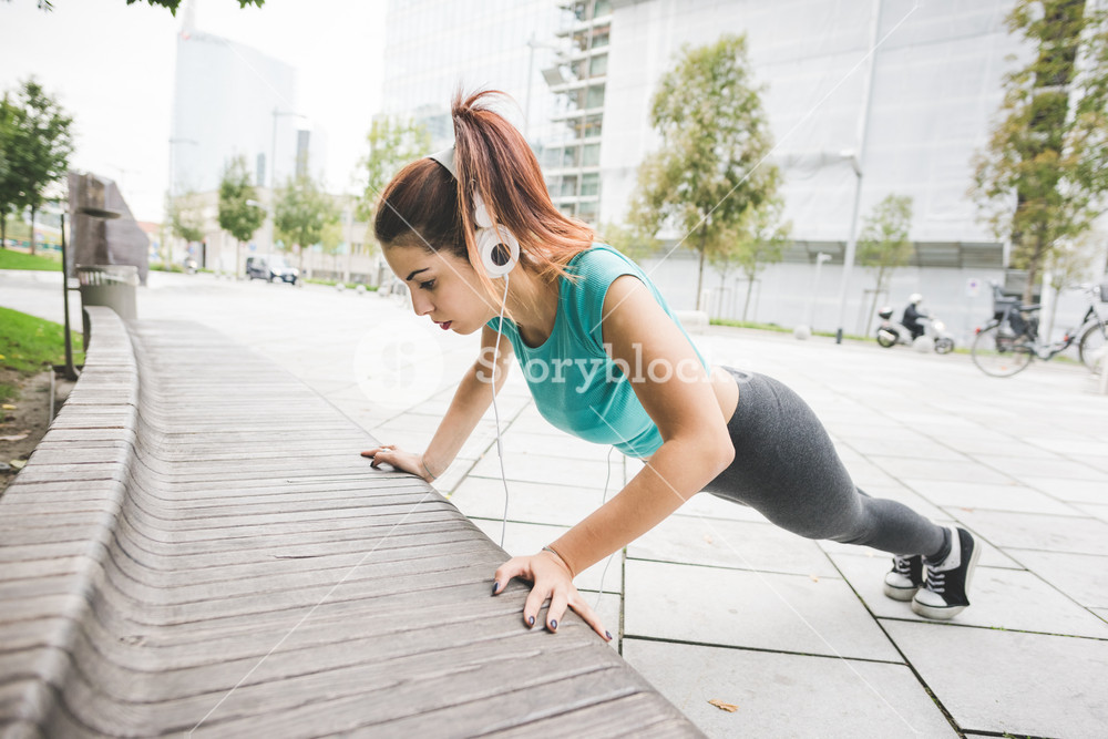 Young person exercising on a bench in a city park - practice, training, fitness, healthy concept