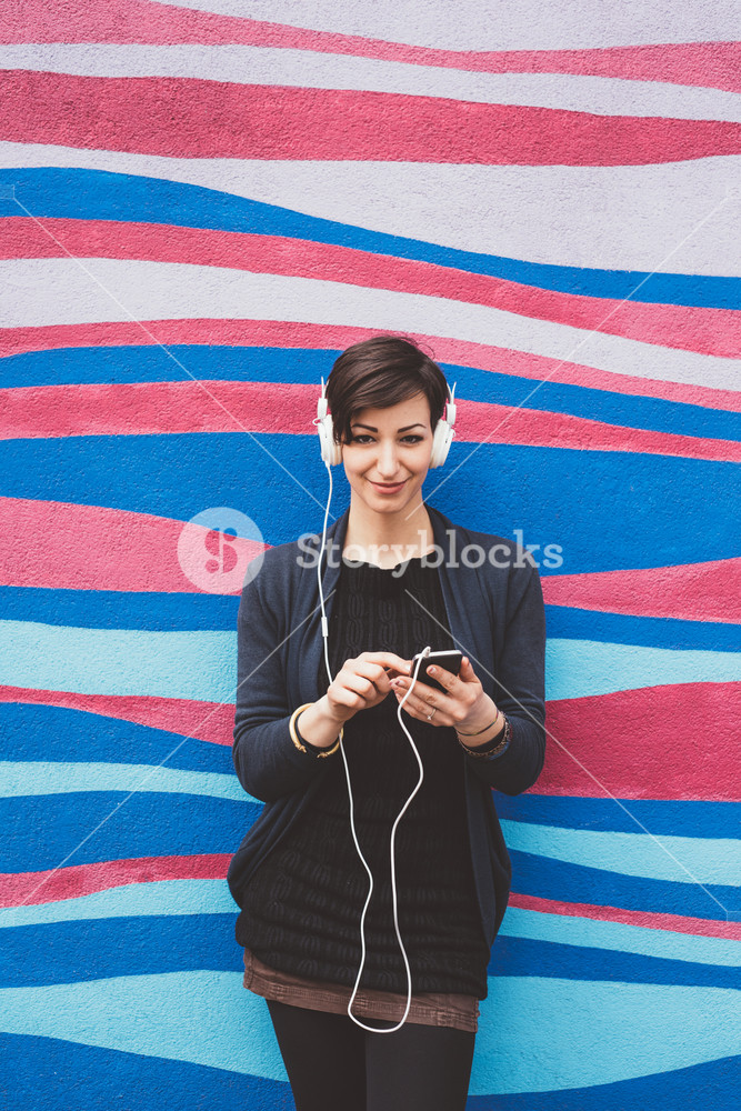 Serene young person enjoying music with headphones and smartphone