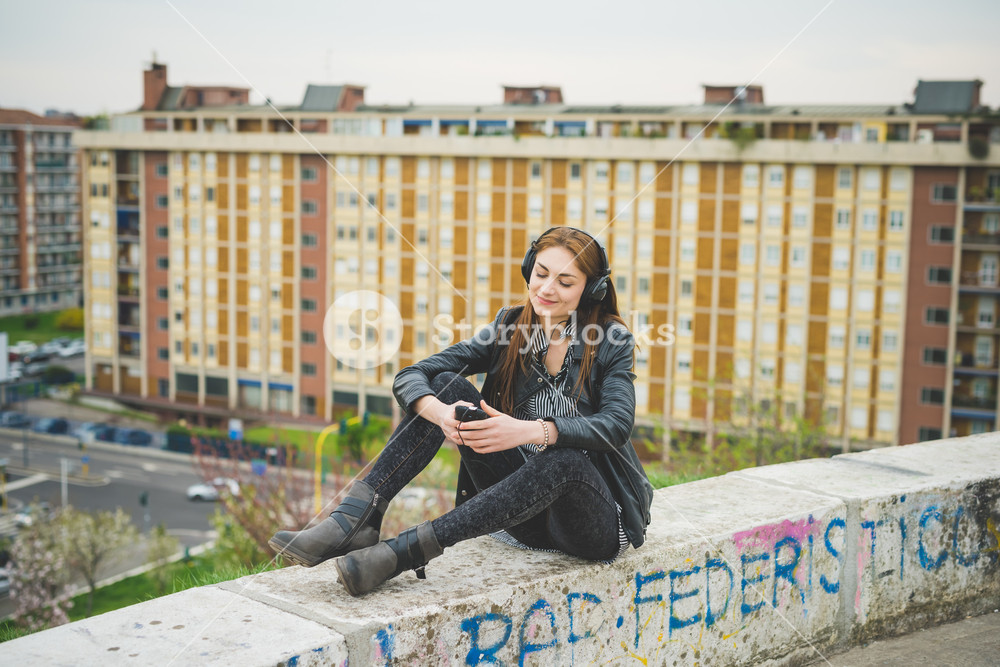 Young person enjoying music in a city park - technology, freedom, emancipation concept