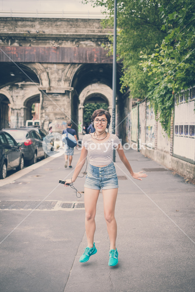 Young woman enjoying music, dancing in the city