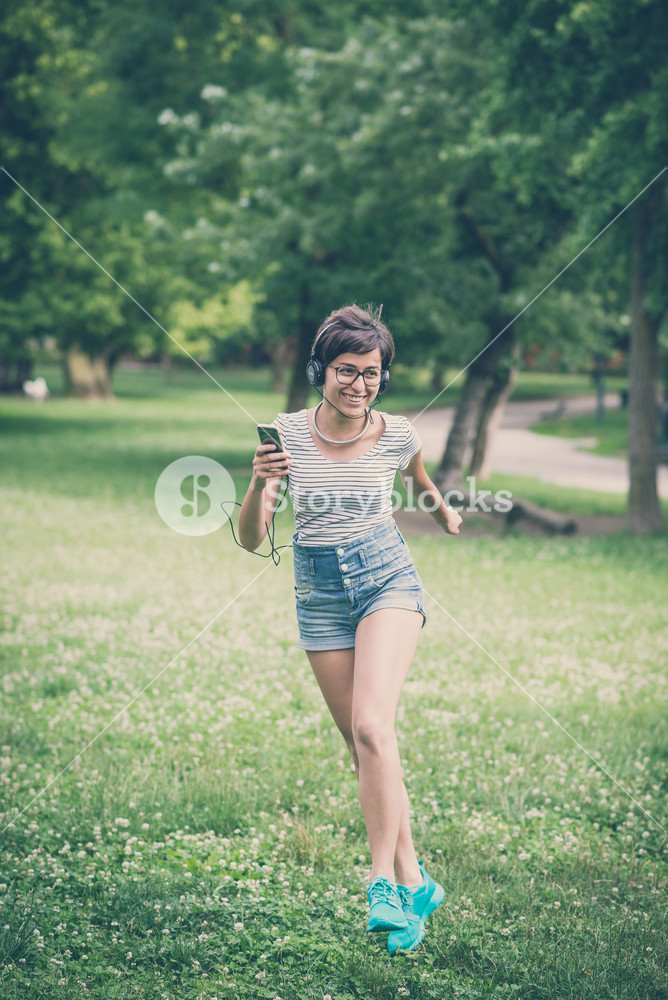 Young woman enjoying music, dancing in the city