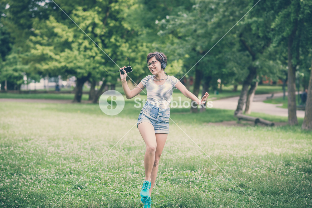 Young woman enjoying music, dancing in the city