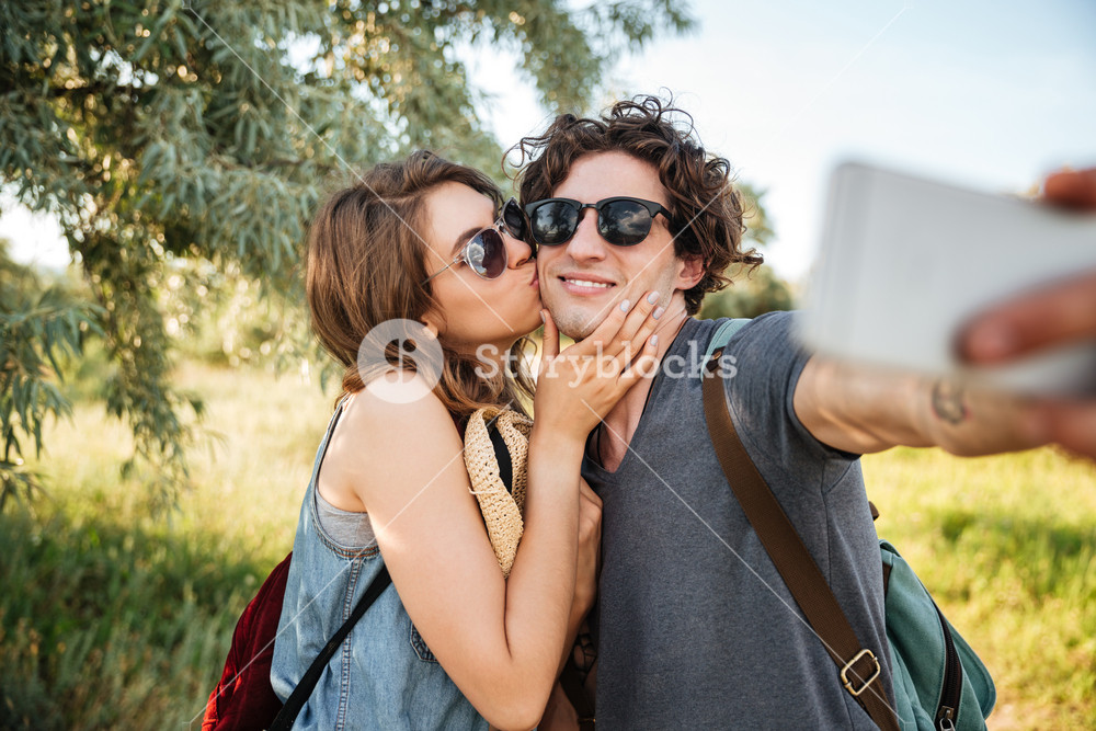 Smiling couple hiking in the forest and taking a selfie Royalty-Free ...