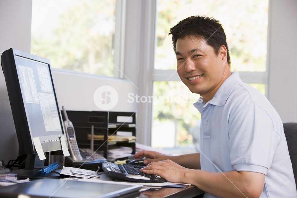 Man in home office using computer and smiling Royalty-Free Stock Photo ...