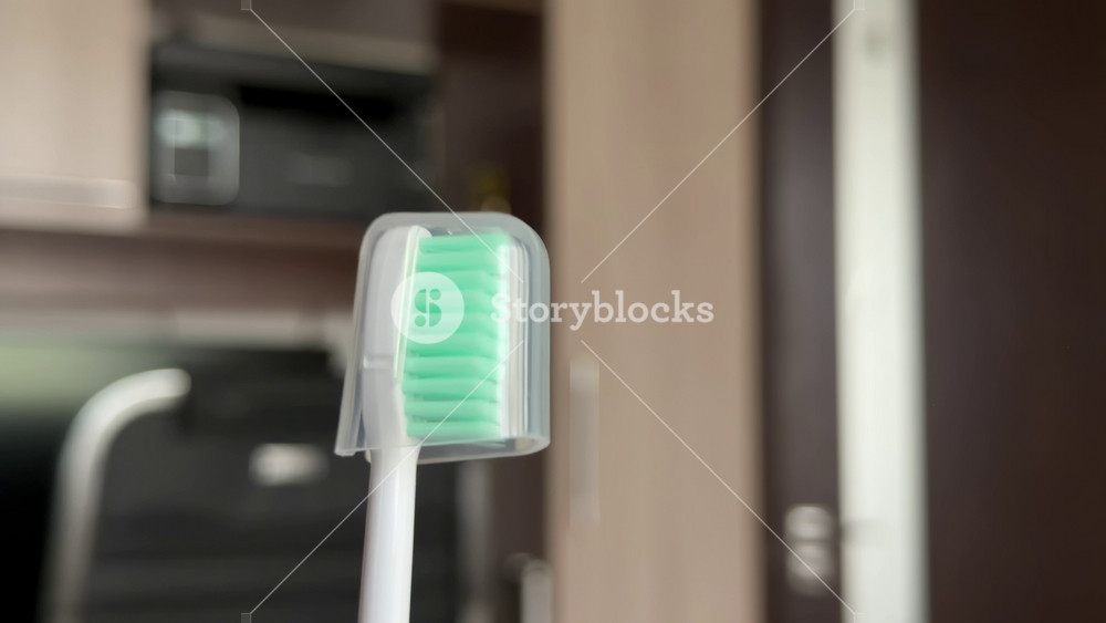 Extreme close-up of a new toothbrush with green bristles and a transparent protective cap, concept of dental care, oral hygiene, and