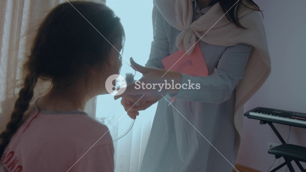 Loving mother with letter S on her chest and superhero cape is giving respiratory mask to treat sickness of her child. Mom with super powers