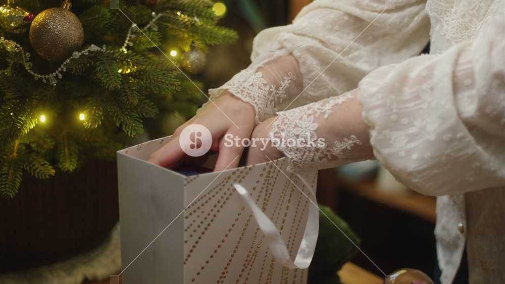 Woman collecting Christmas presents in a gift bag. Concept of giving gifts for Christmas or donating gifts for children