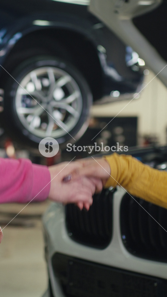 Women in the automotive repair and maintenance industry, a female mechanic shaking hands with a customer and returning her car keys.